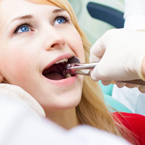 A woman in a dentist's chair being examined.